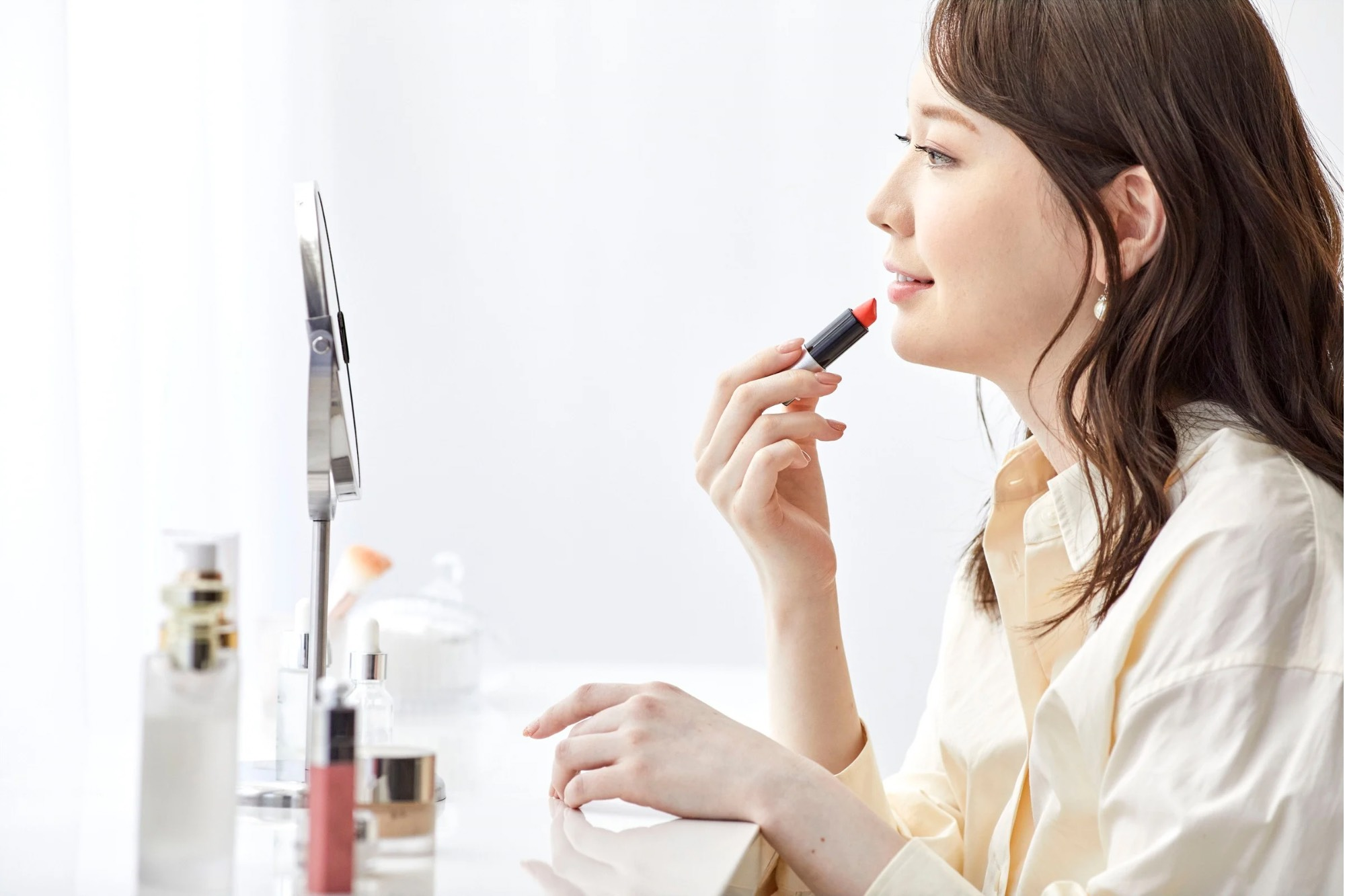 女性が楽しそうにメイクしている写真